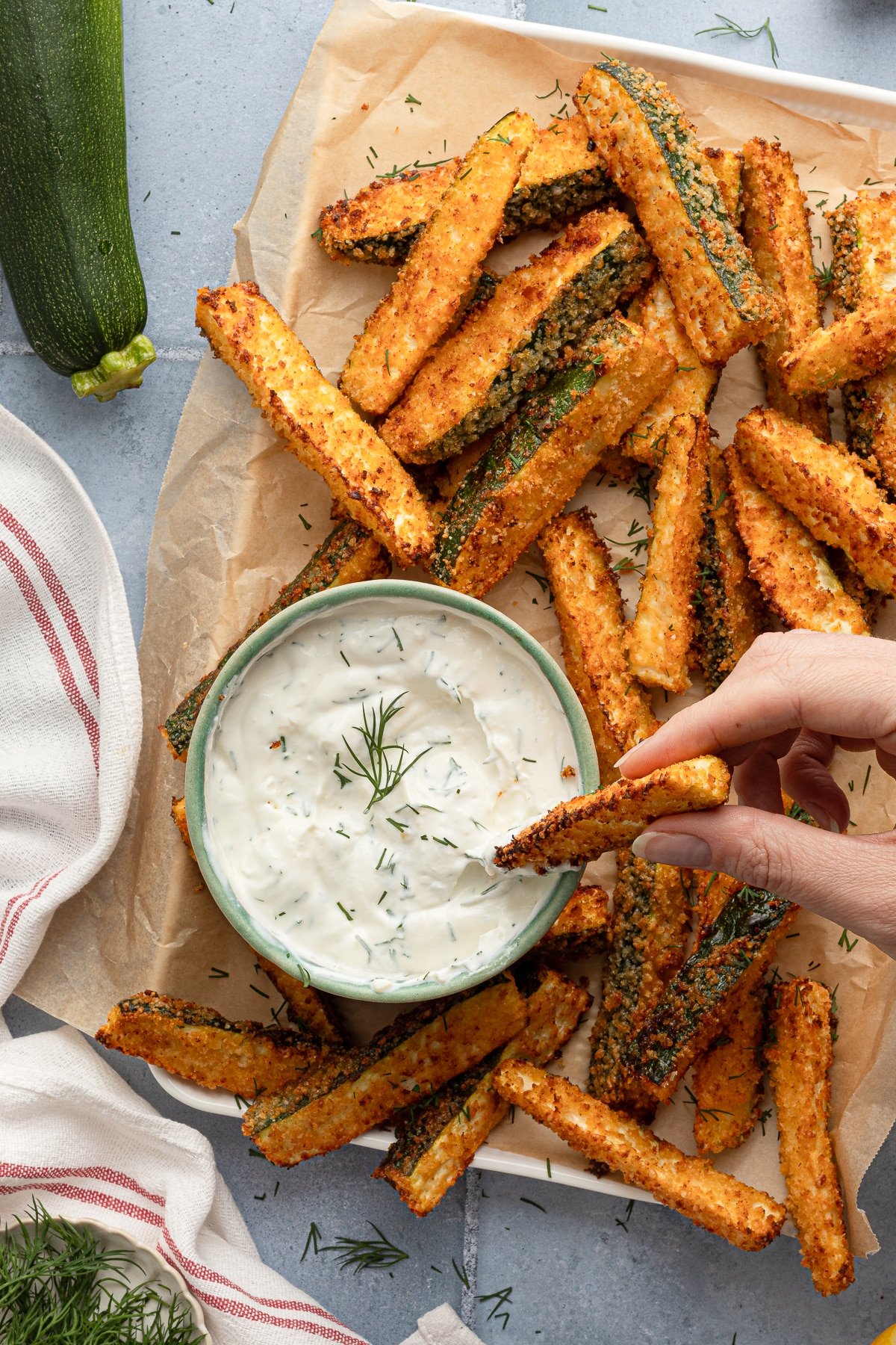 Dipping a zucchini fry into a bowl of Greek yogurt dill dip.