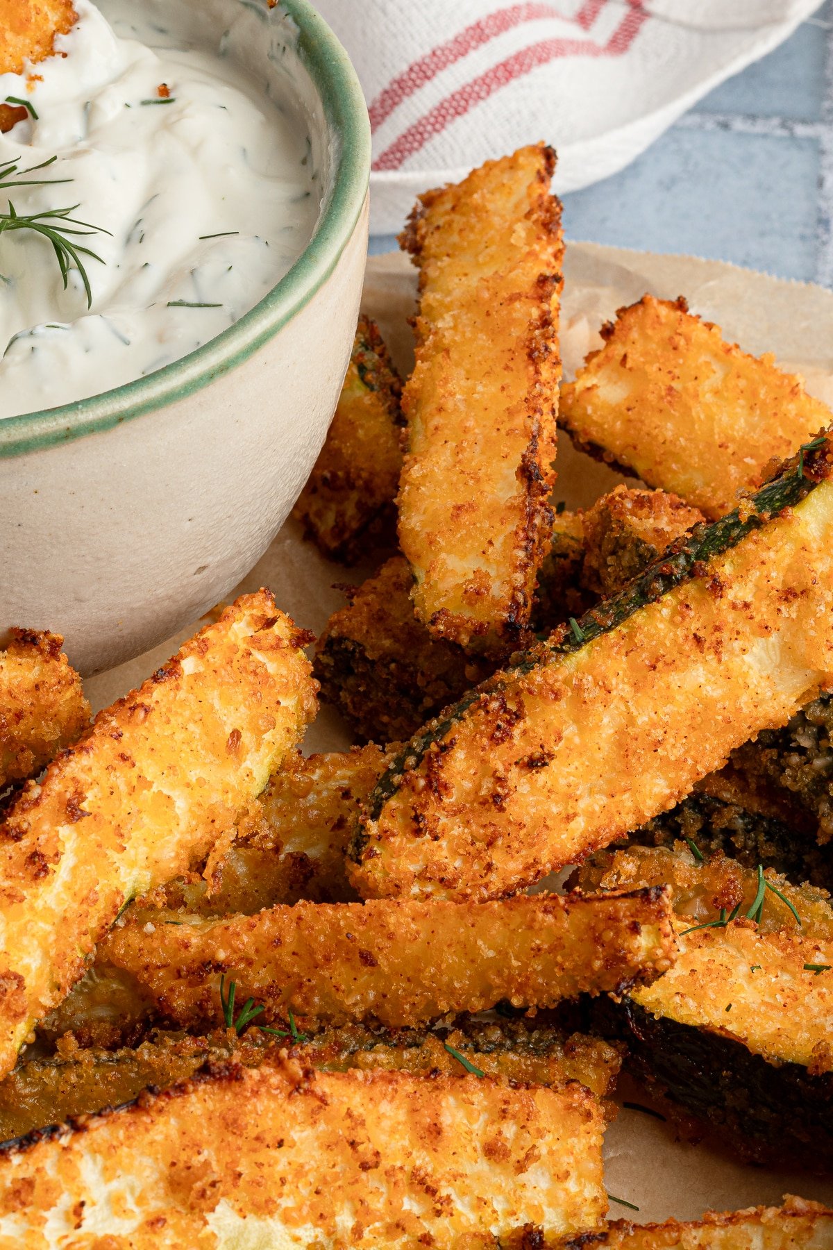 Air fryer zucchini fries on a plate with Greek yogurt dip.