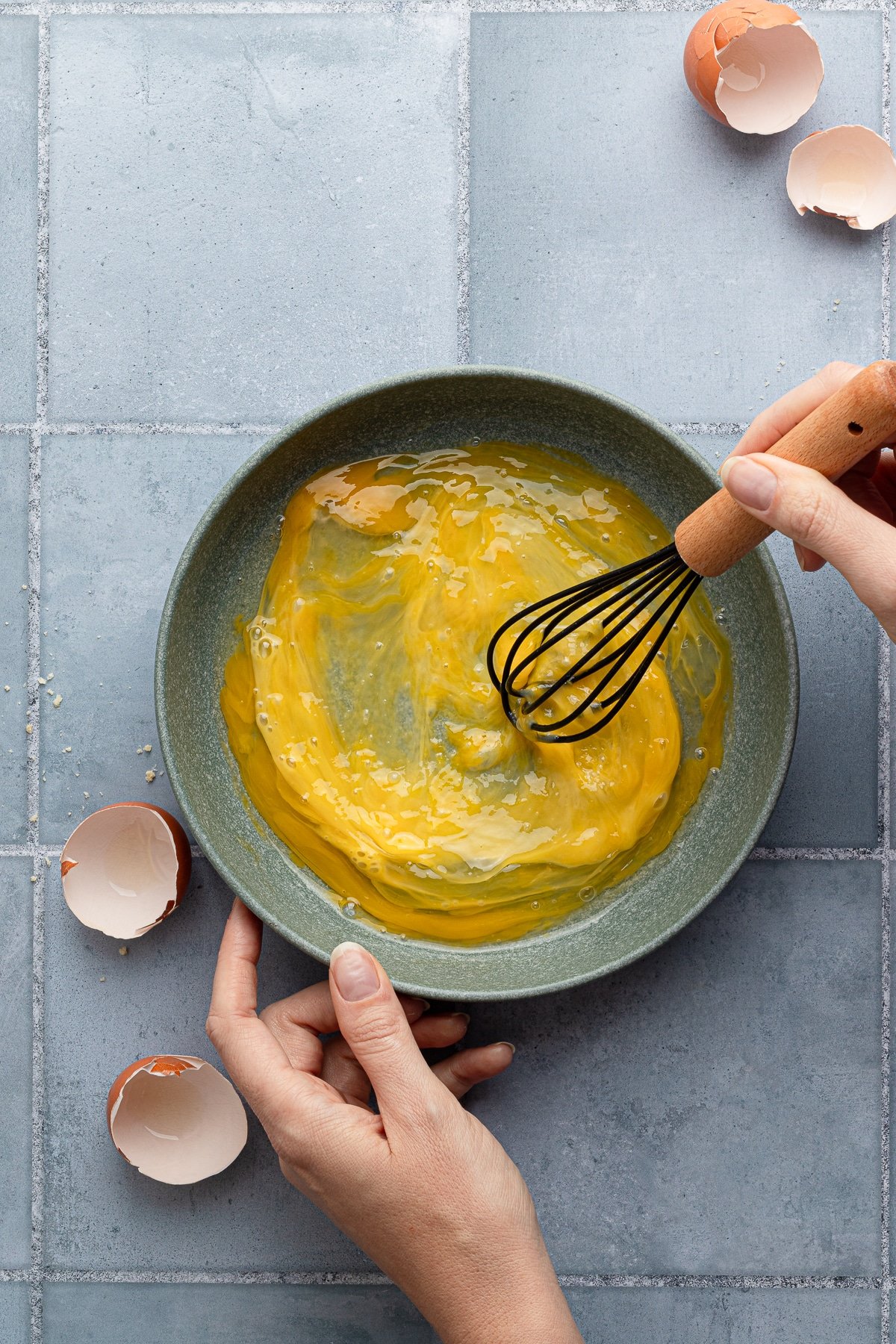 Whisking together 2 eggs in a shallow bowl.