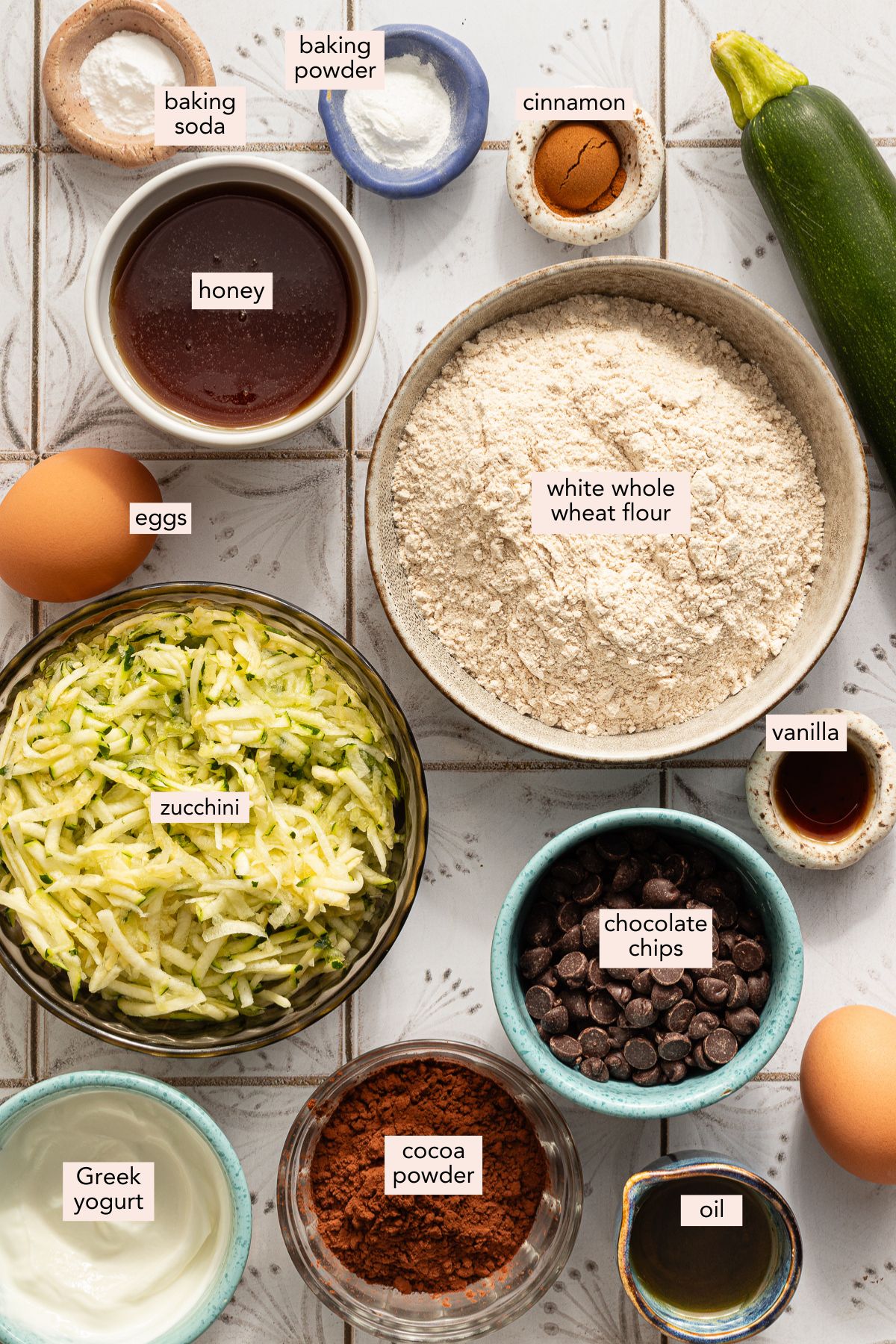 Ingredients for healthy chocolate zucchini bread on a countertop with labels.