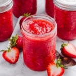 Low sugar strawberry freezer jam in jars on a marble slab.