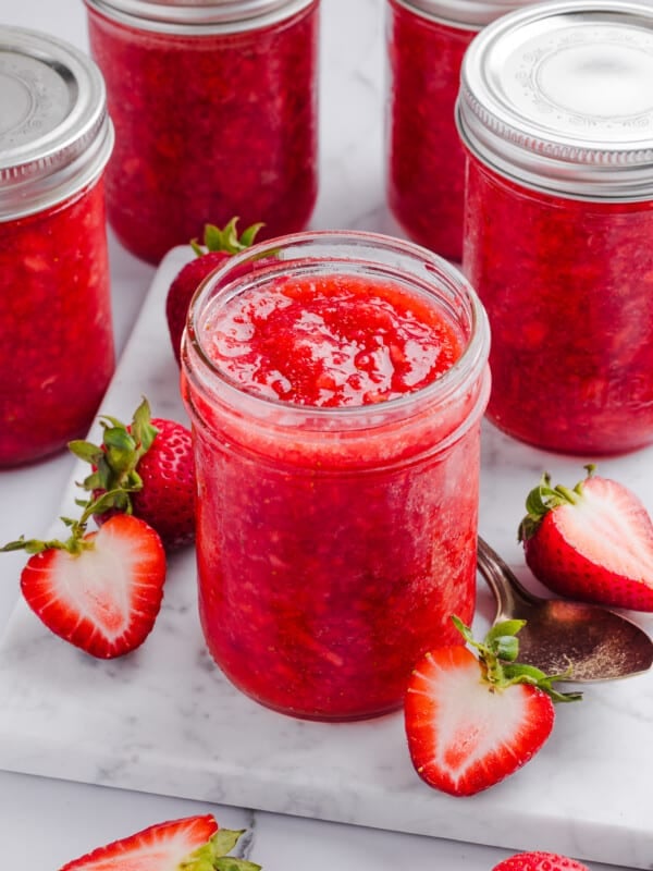 Low sugar strawberry freezer jam in jars on a marble slab.
