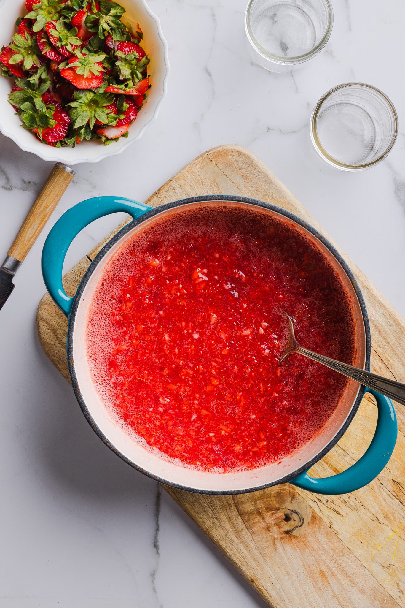 Fresh strawberries mixed with sugar and pectin in a saucepan.