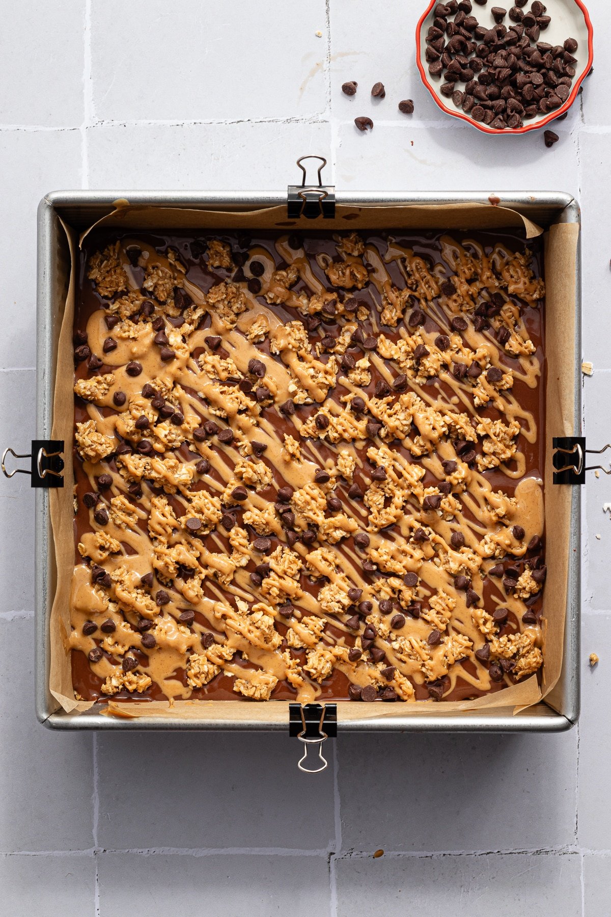No bake chocolate oat bars in a square baking dish before being sliced.