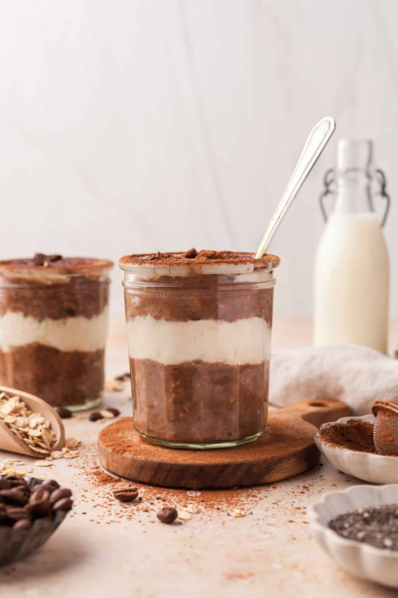A jar of tiramisu oats with a spoon in it.