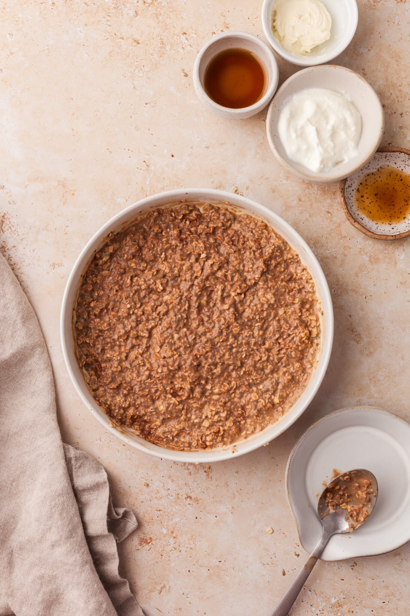 Oats, Greek yogurt, milk, chia seeds, instant coffee, and maple syrup mixed together in a bowl.