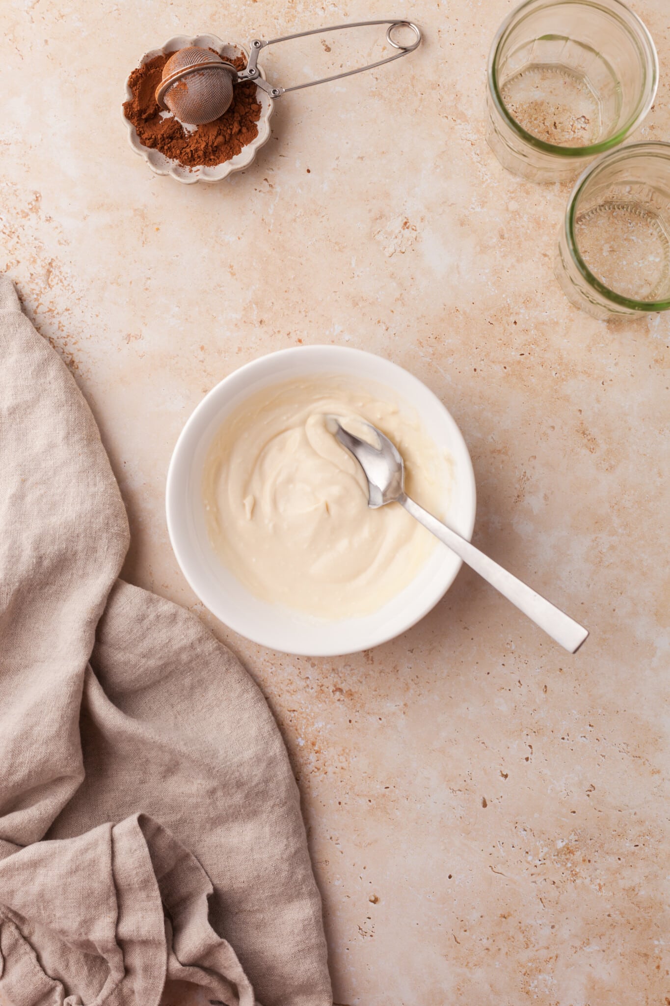 Yogurt, maple syrup, vanilla, and mascarpone mixed together in a bowl.