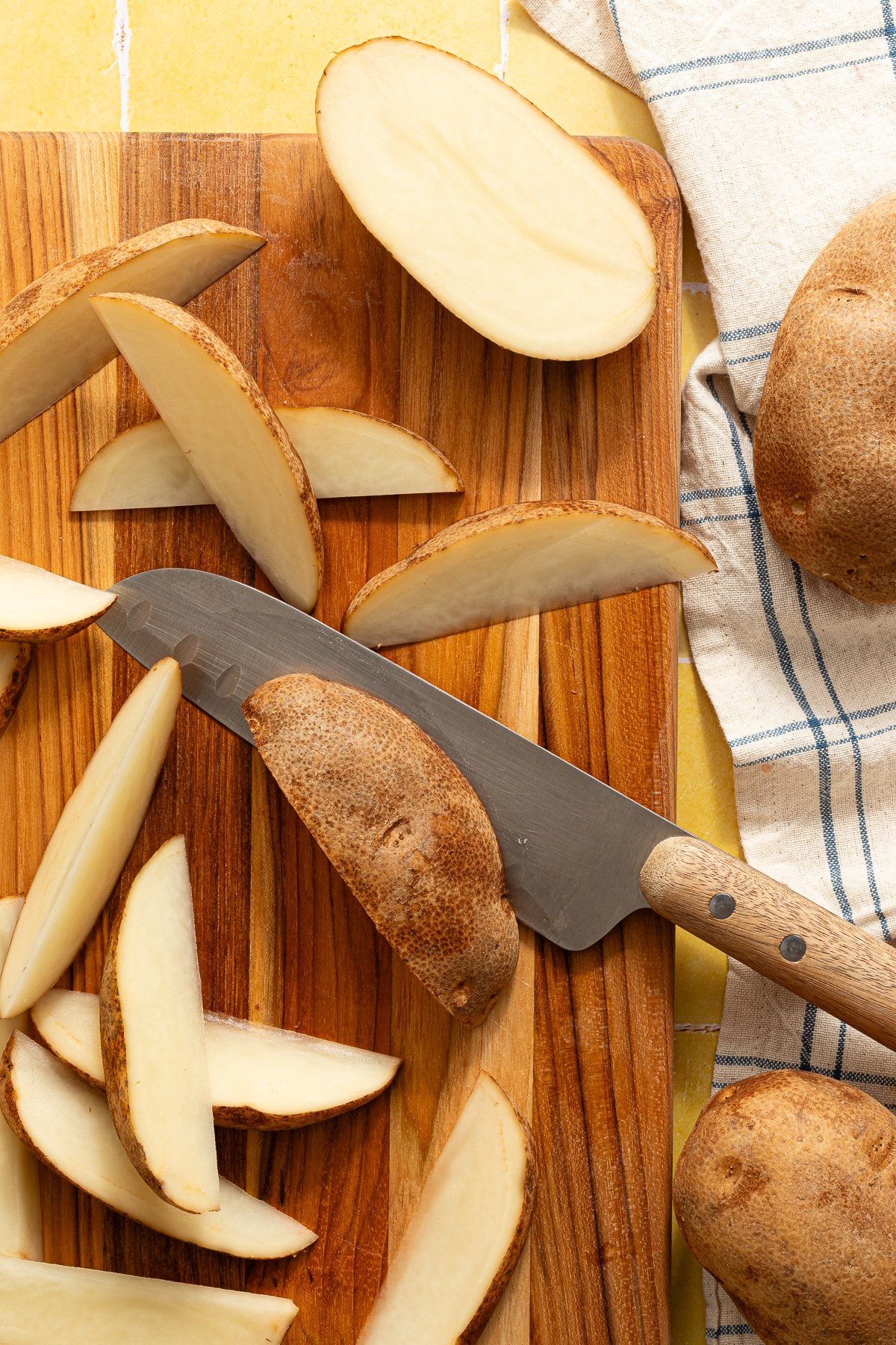 Slicing russet potatoes into wedges.