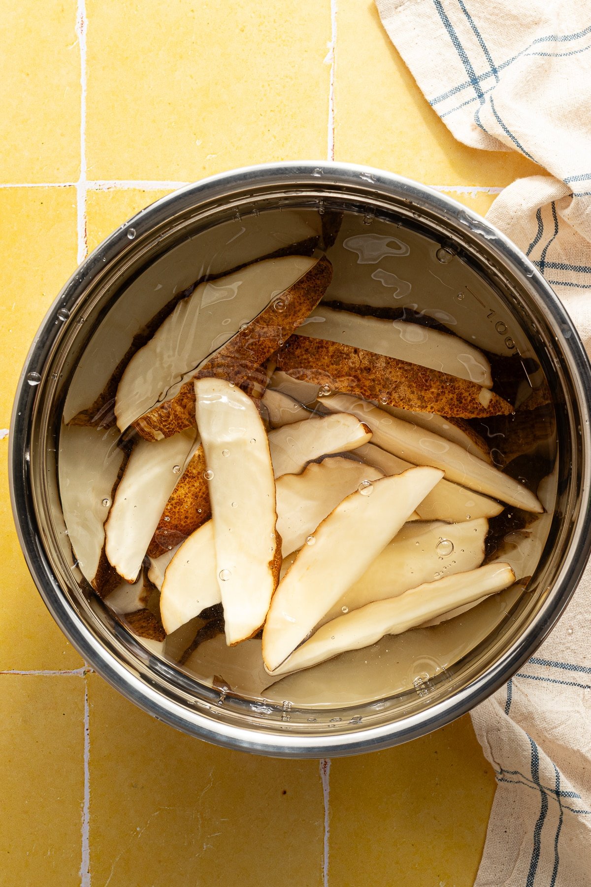 Soaking potato wedges in cold water.