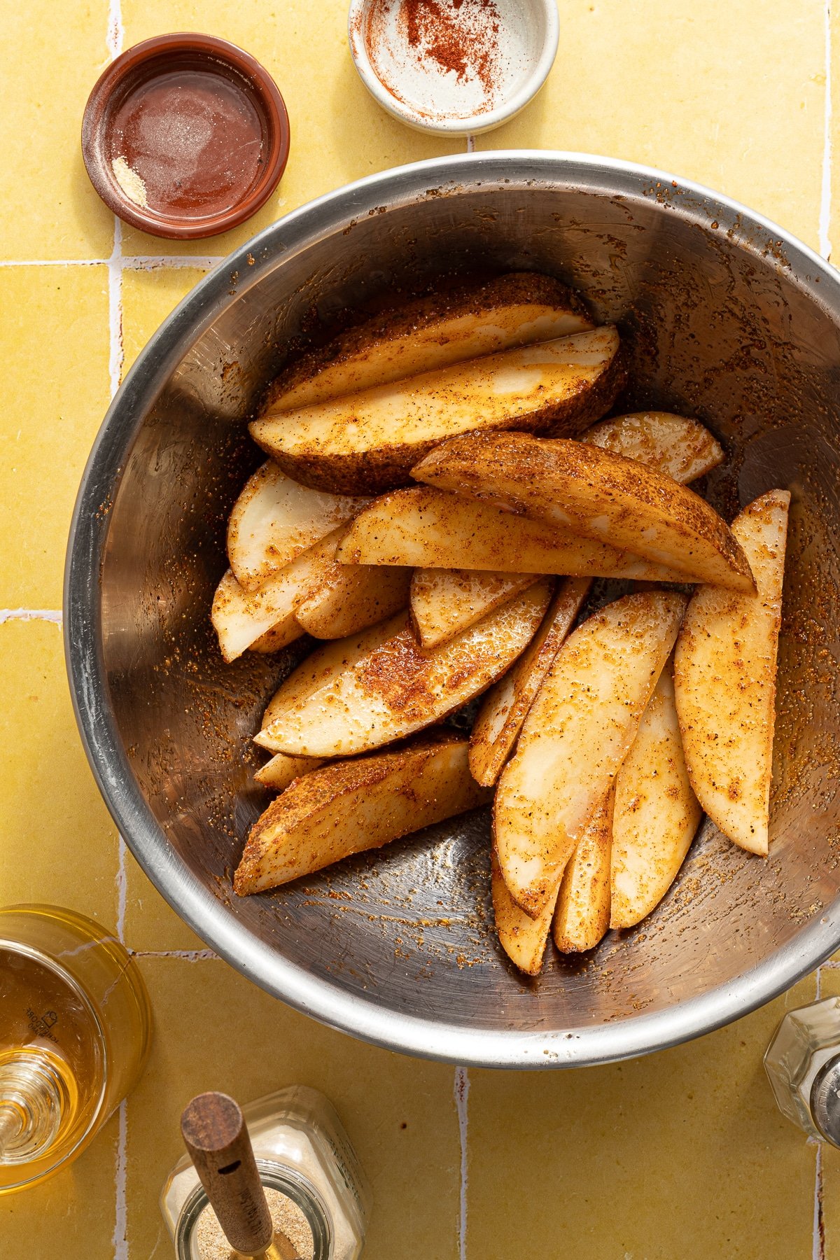 Potato wedges tossed with oil, salt, garlic powder, onion powder, paprika, and black pepper.