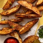 Overhead image of crispy potato wedges with ketchup.