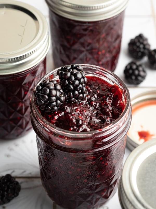 Blackberry jam with two blackberries on top.