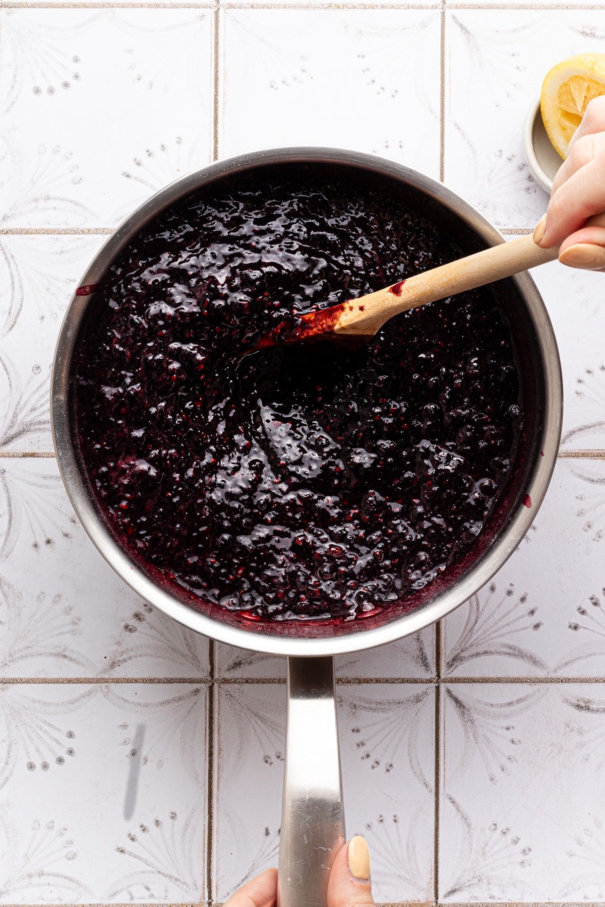 Blackberries being mixed with lemon juice, pectin and sugar for freezer jam in a saucepan.