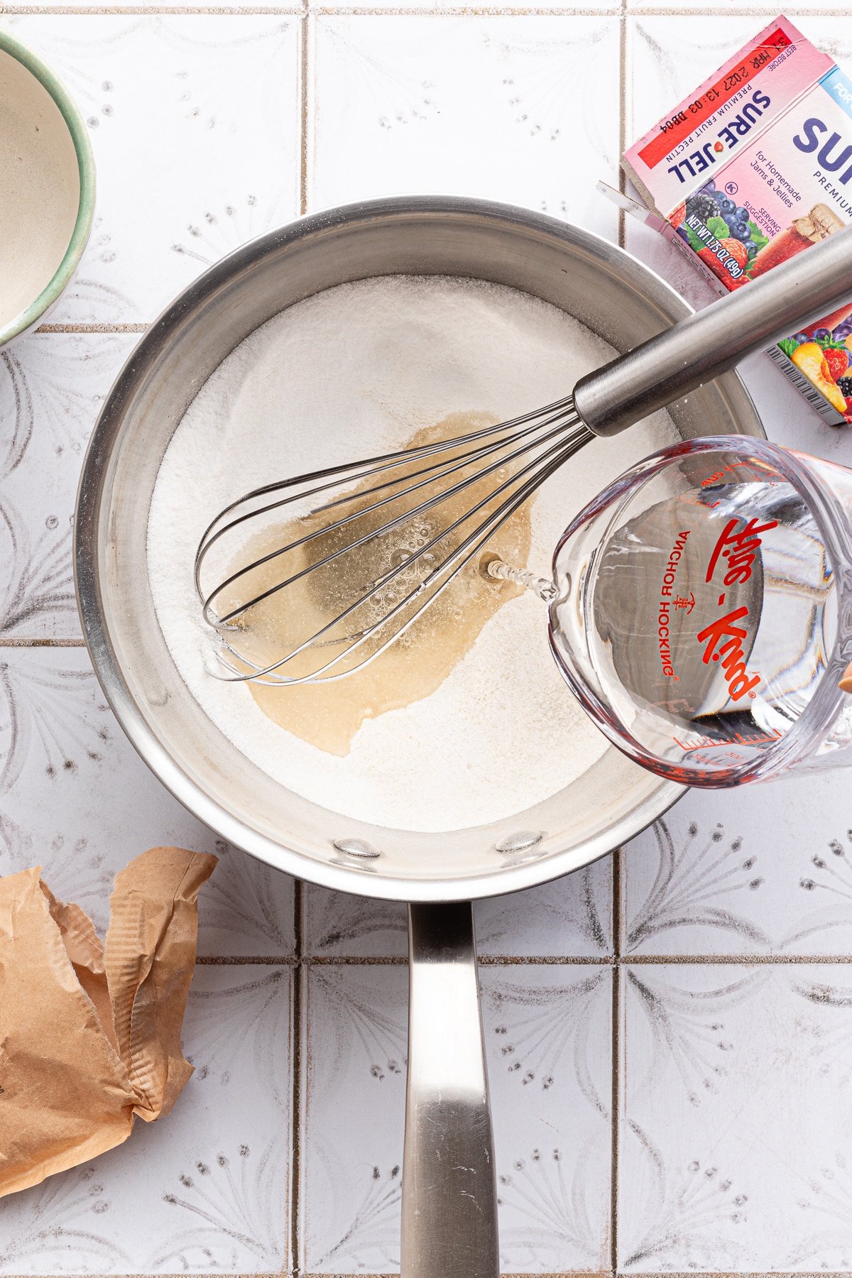 Pectin and sugar whisked together in a saucepan with the water being added.