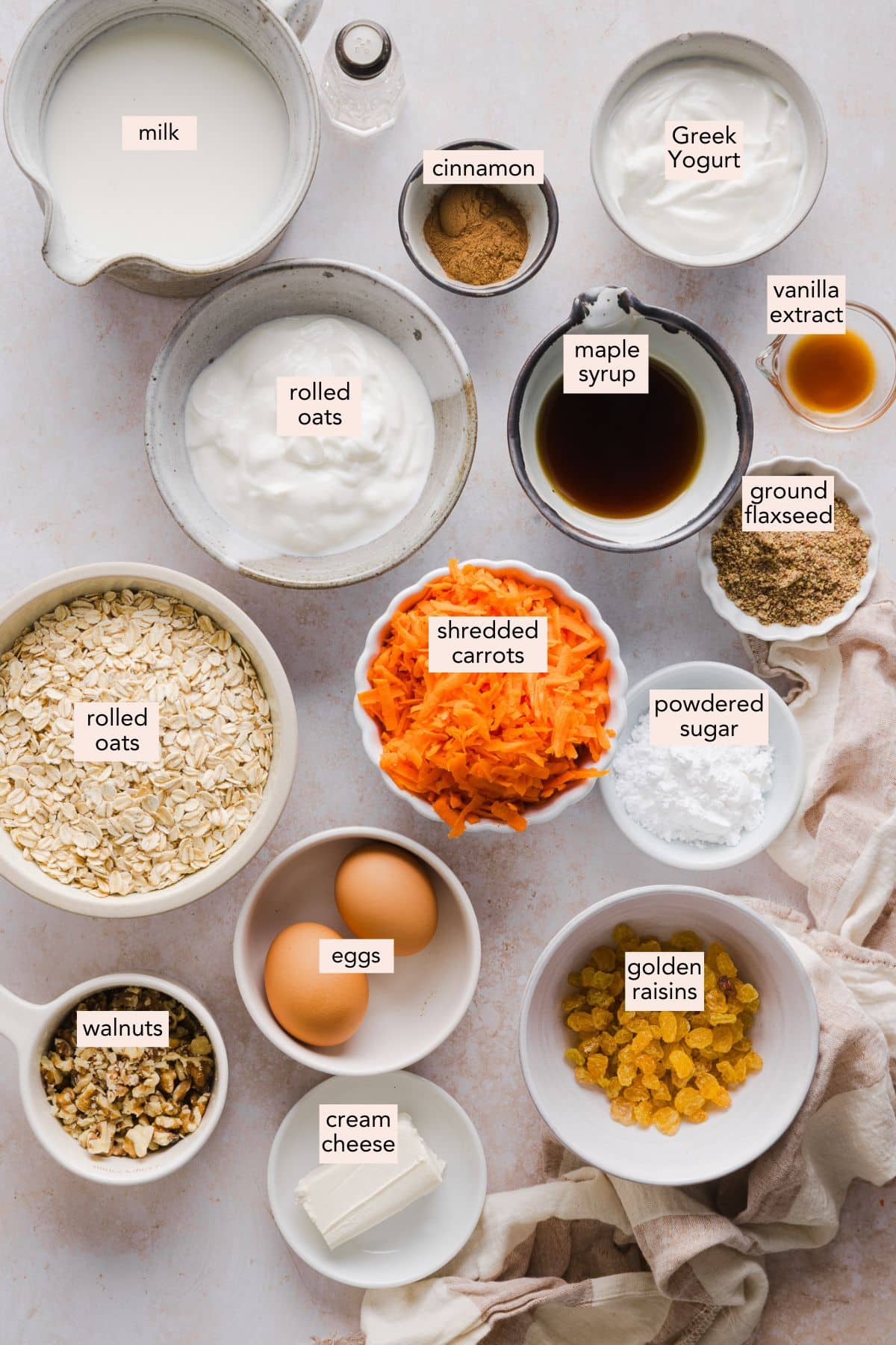 Ingredients for carrot cake baked oats on a countertop with labels.