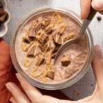 Chocolate peanut butter overnight oats in a jar with a spoon.