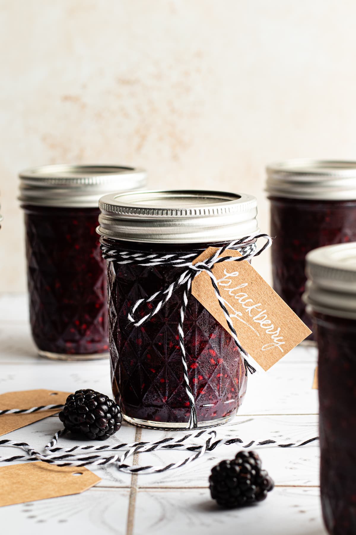 Blackberry freezer jam in a mason jar with a brown paper label.