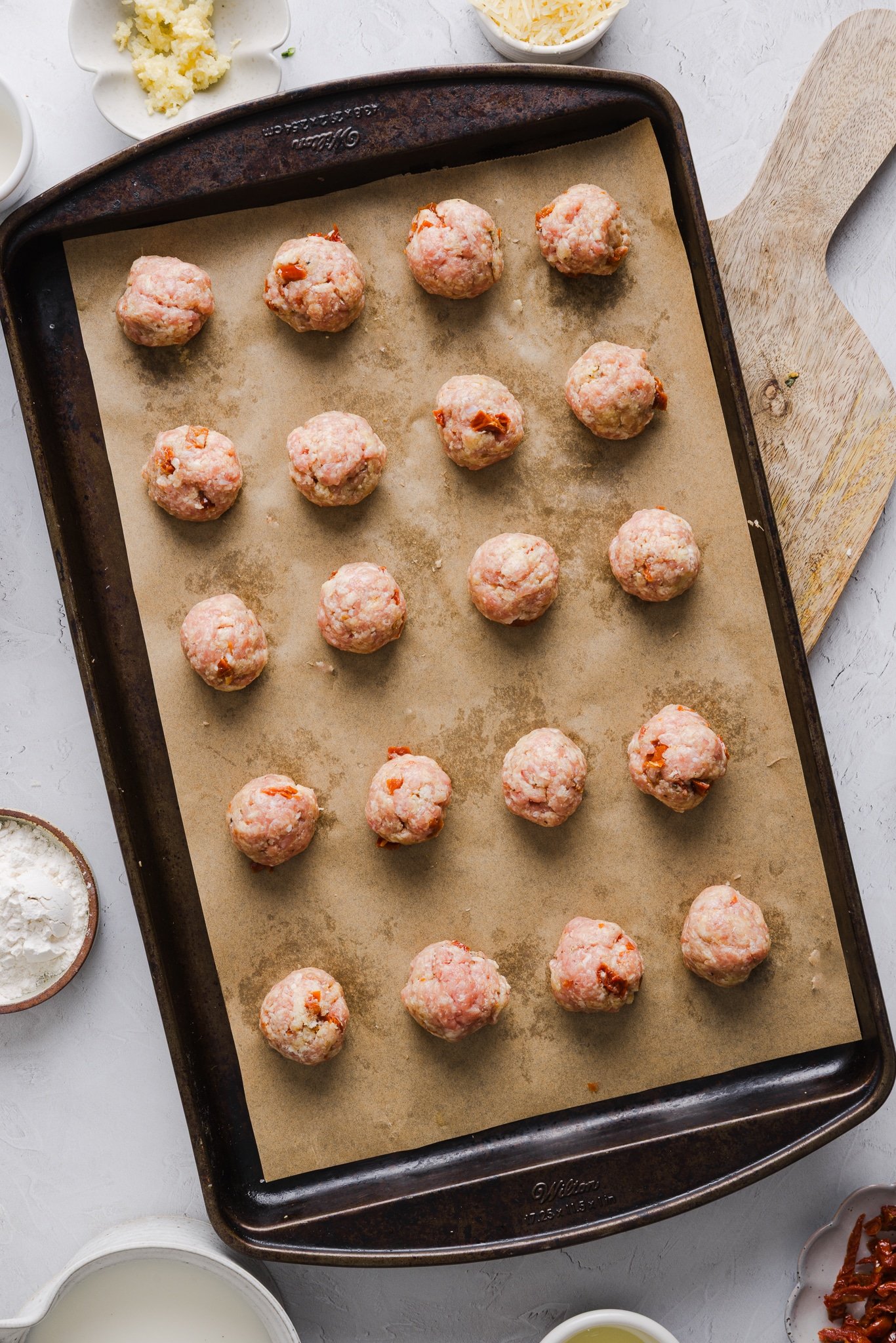 Marry me chicken meatballs on a sheet pan ready for the oven.