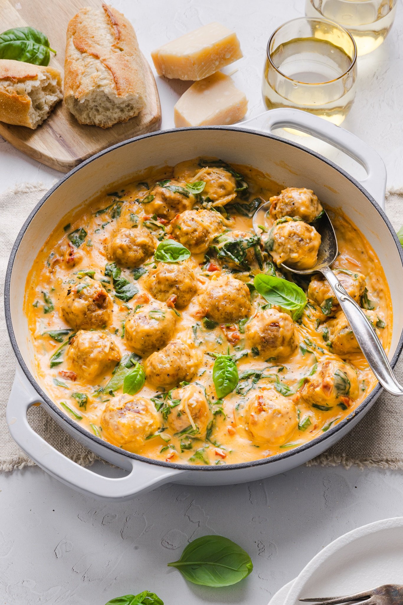 Marry me chicken meatballs in a sauté pan garnished with basil.