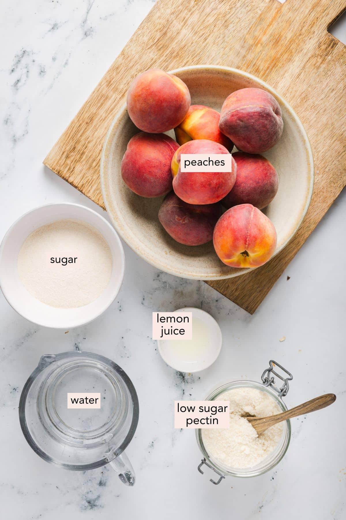 Ingredients for low sugar peach freezer jam on a countertop with labels.