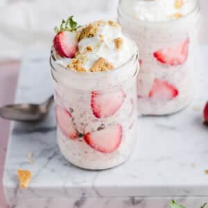 Strawberry cheesecake overnight oats topped with graham crackers and strawberries.