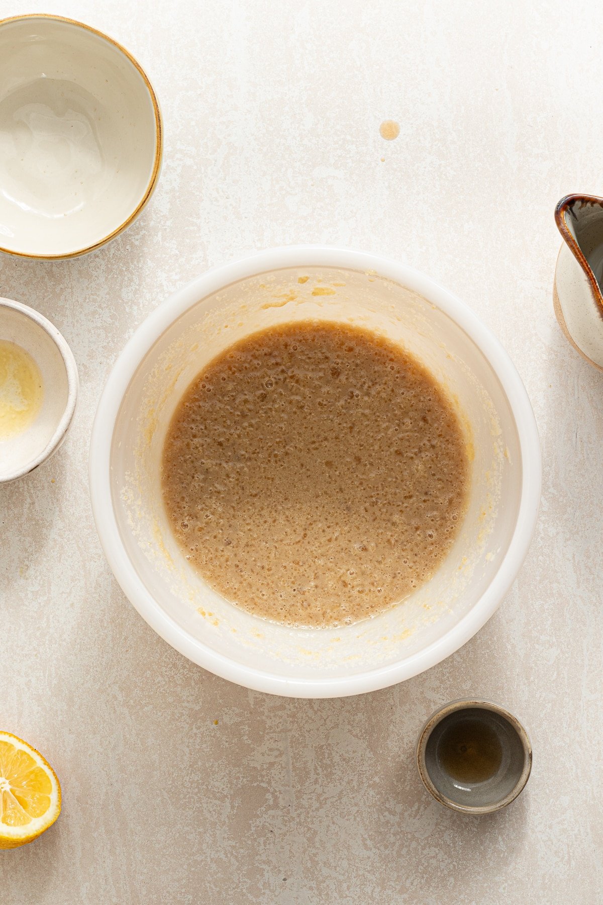 Brown sugar mixed with milk and melted butter in a white bowl.