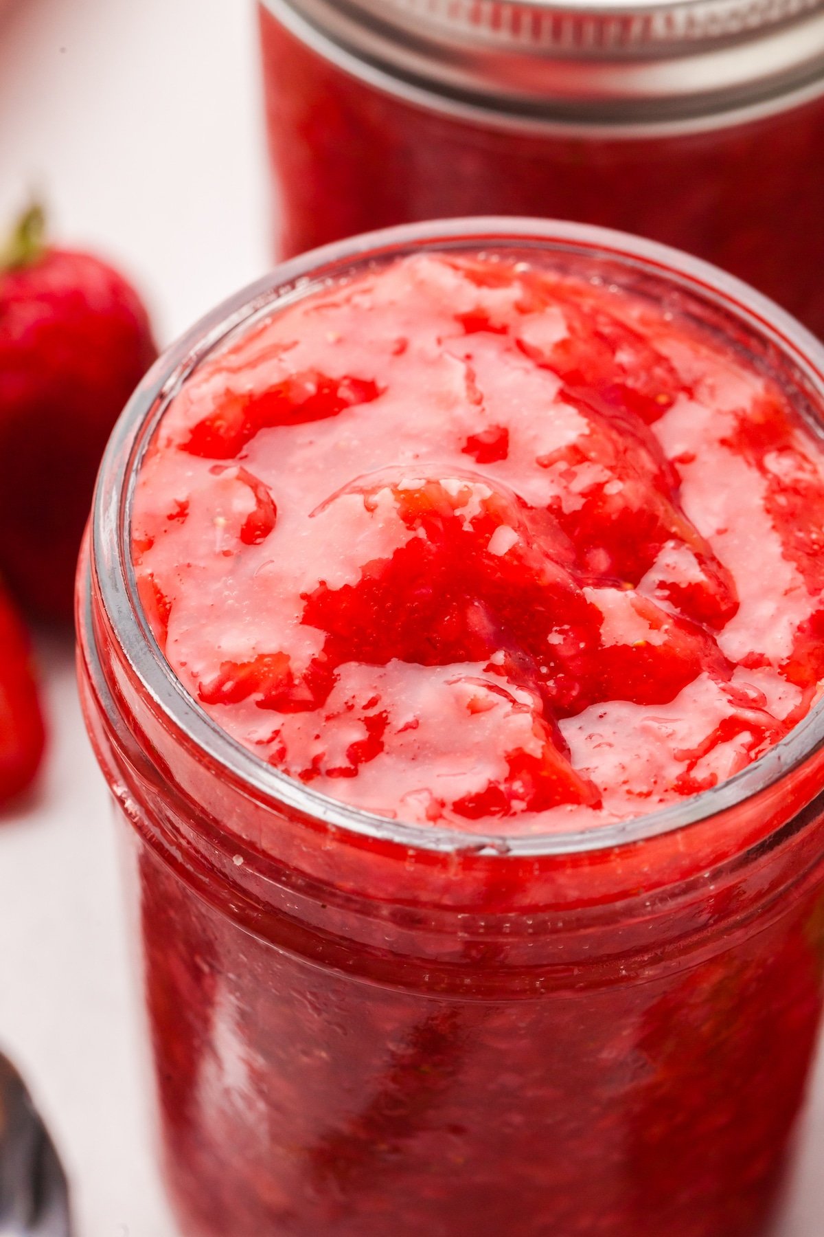 Low sugar strawberry rhubarb freezer jam in a mason jar.