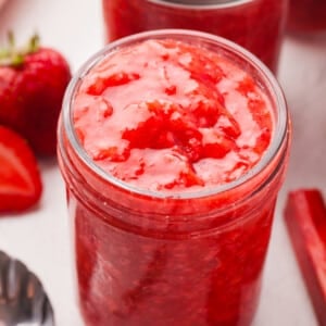 Low sugar strawberry rhubarb freezer jam in a mason jar.