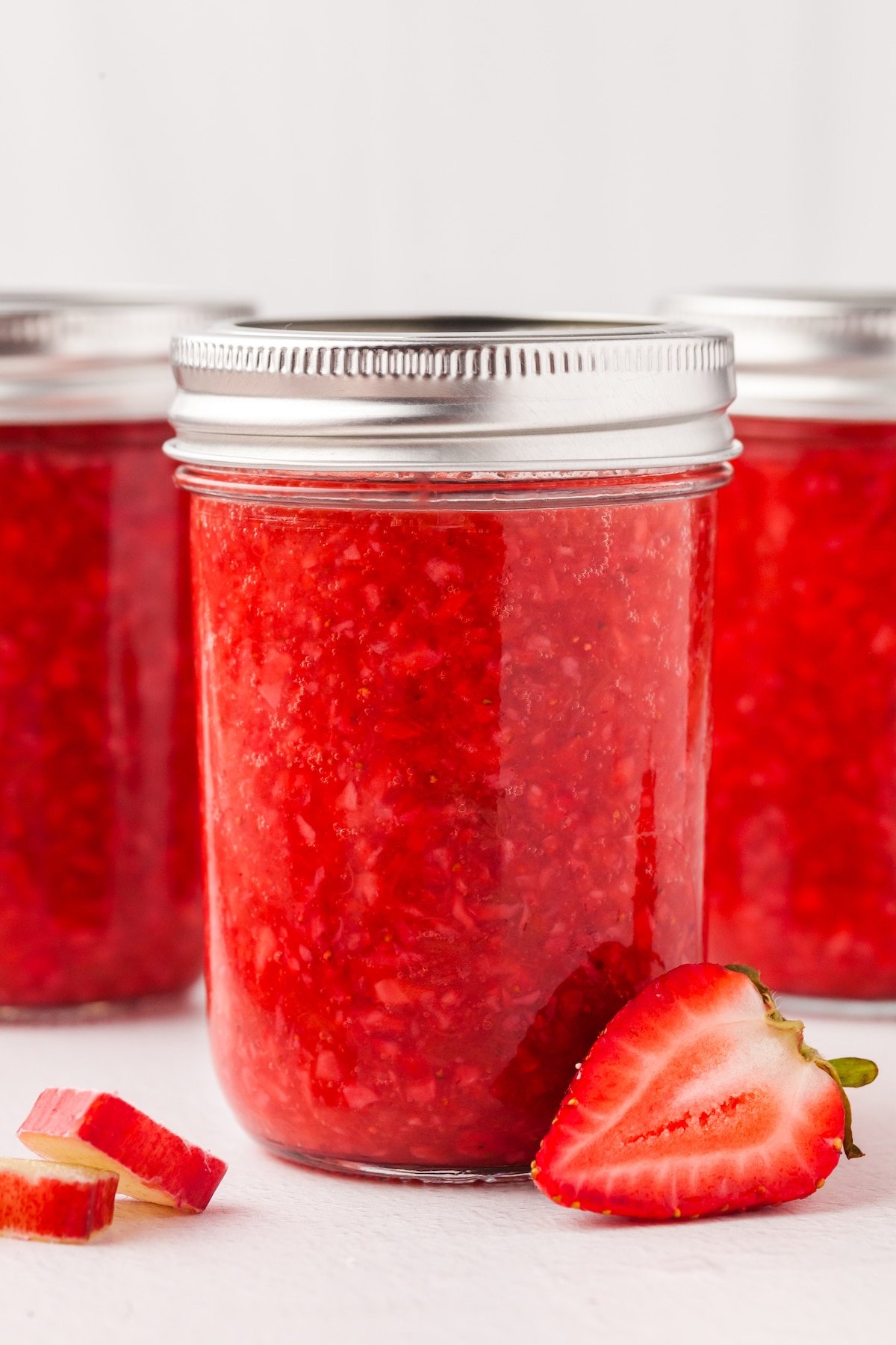 Low sugar strawberry rhubarb freezer jam in a mason jar with a lid.