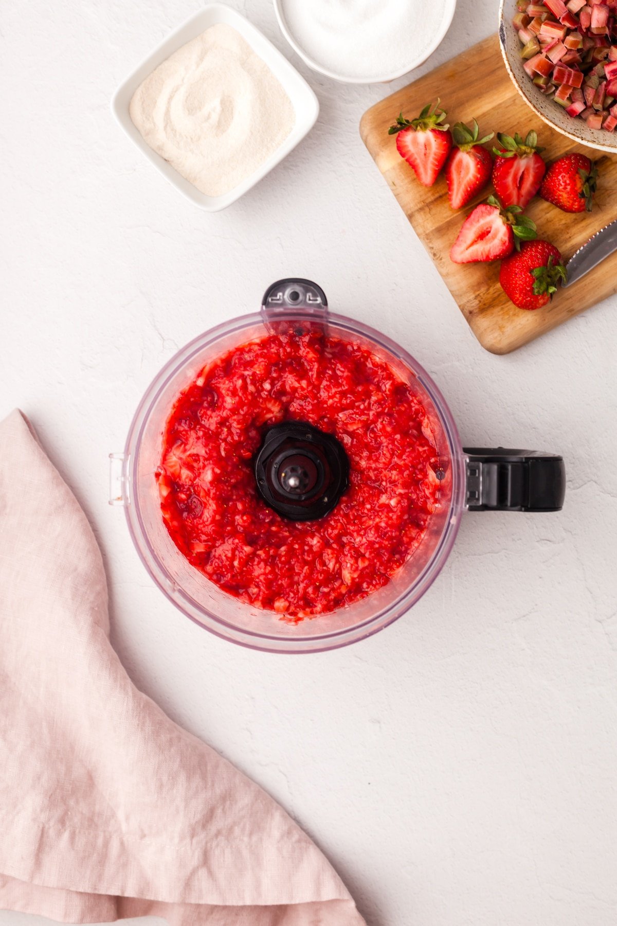 Strawberries being pulsed in a food processor.