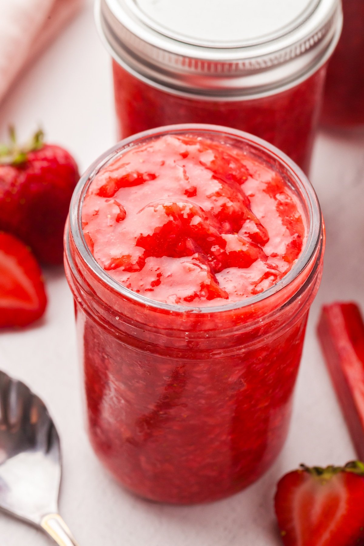 Low sugar strawberry rhubarb freezer jam in a mason jar.
