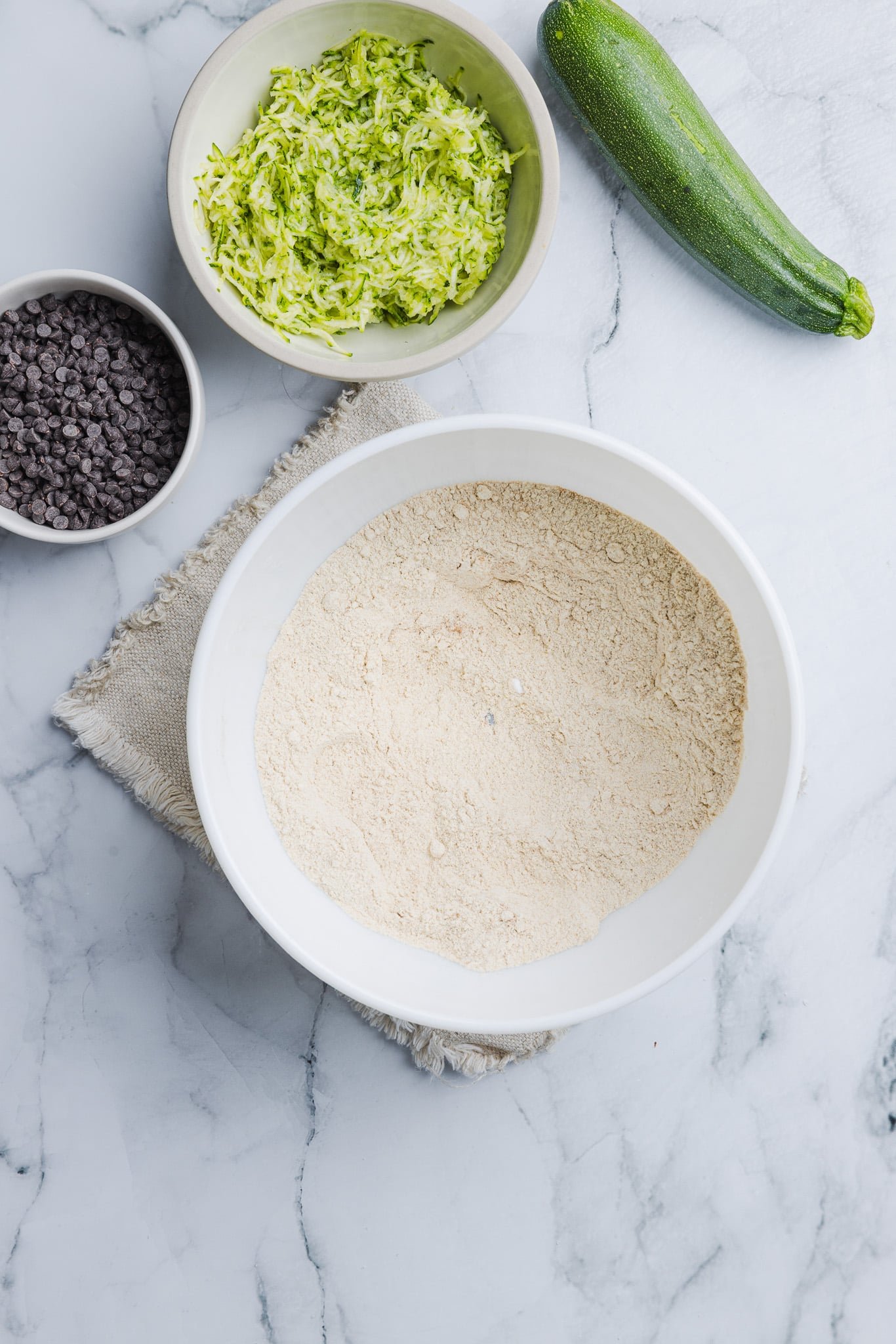 Dry ingredients for zucchini protein muffins being mixed in a bowl.