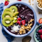 An acai bowl topped with fresh fruit, coconut flakes, and granola.