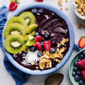 An acai bowl topped with fresh fruit, coconut flakes, and granola.