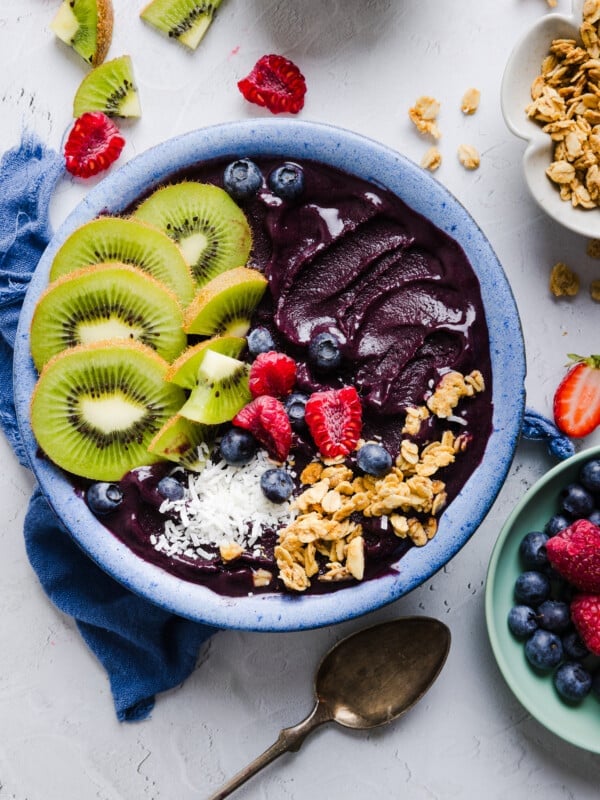An acai bowl topped with fresh fruit, coconut flakes, and granola.
