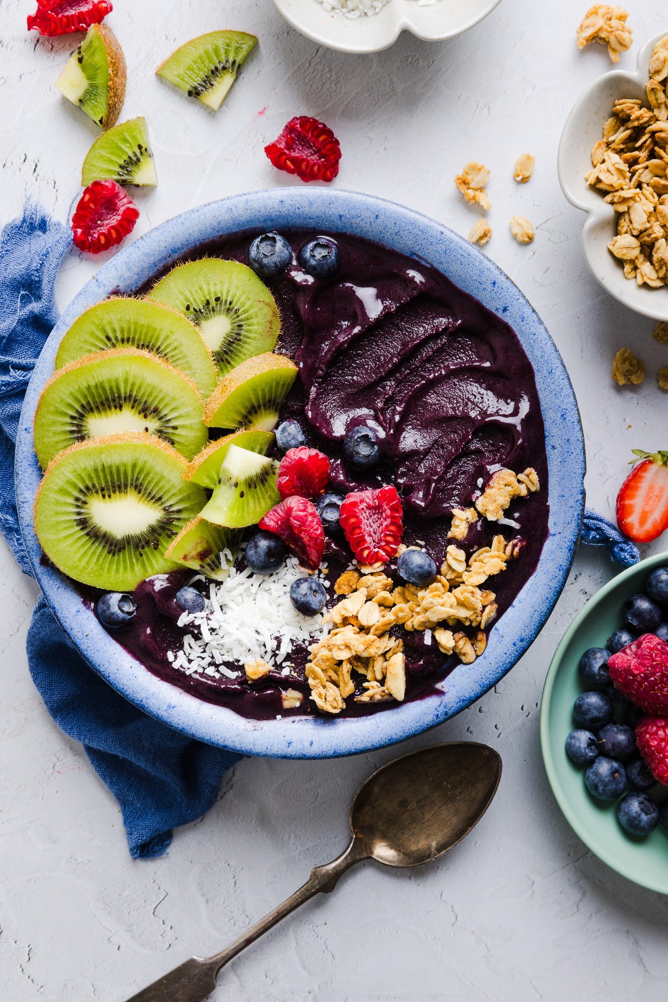 An acai bowl topped with fresh fruit, coconut flakes, and granola. 