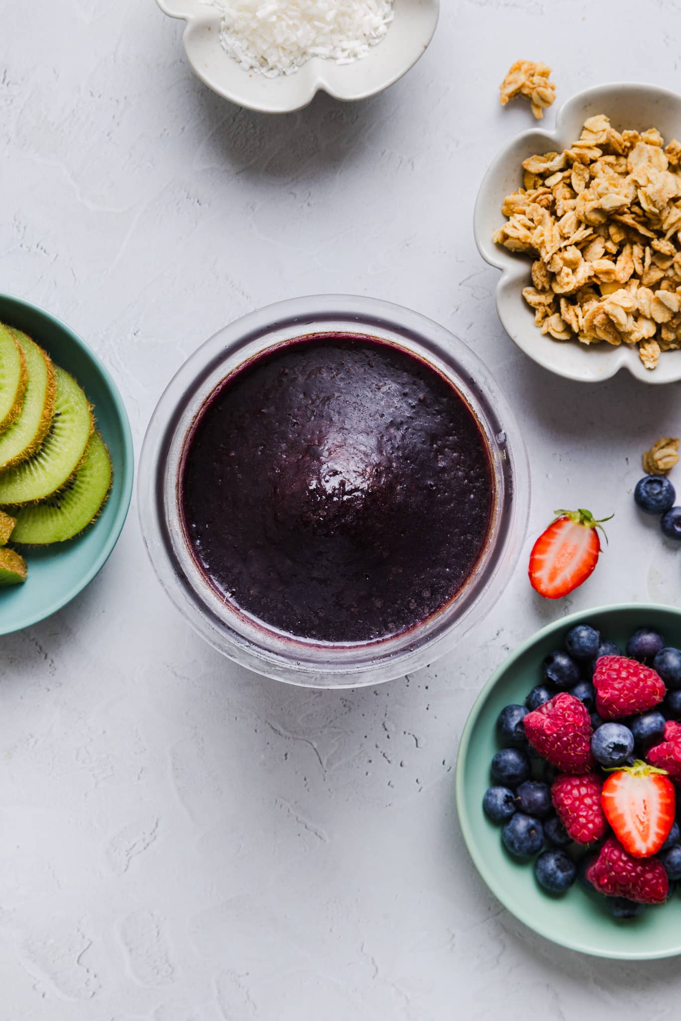 Blended (and frozen) acai, blueberries, banana slices, and coconut water in Ninja Creami pint container.