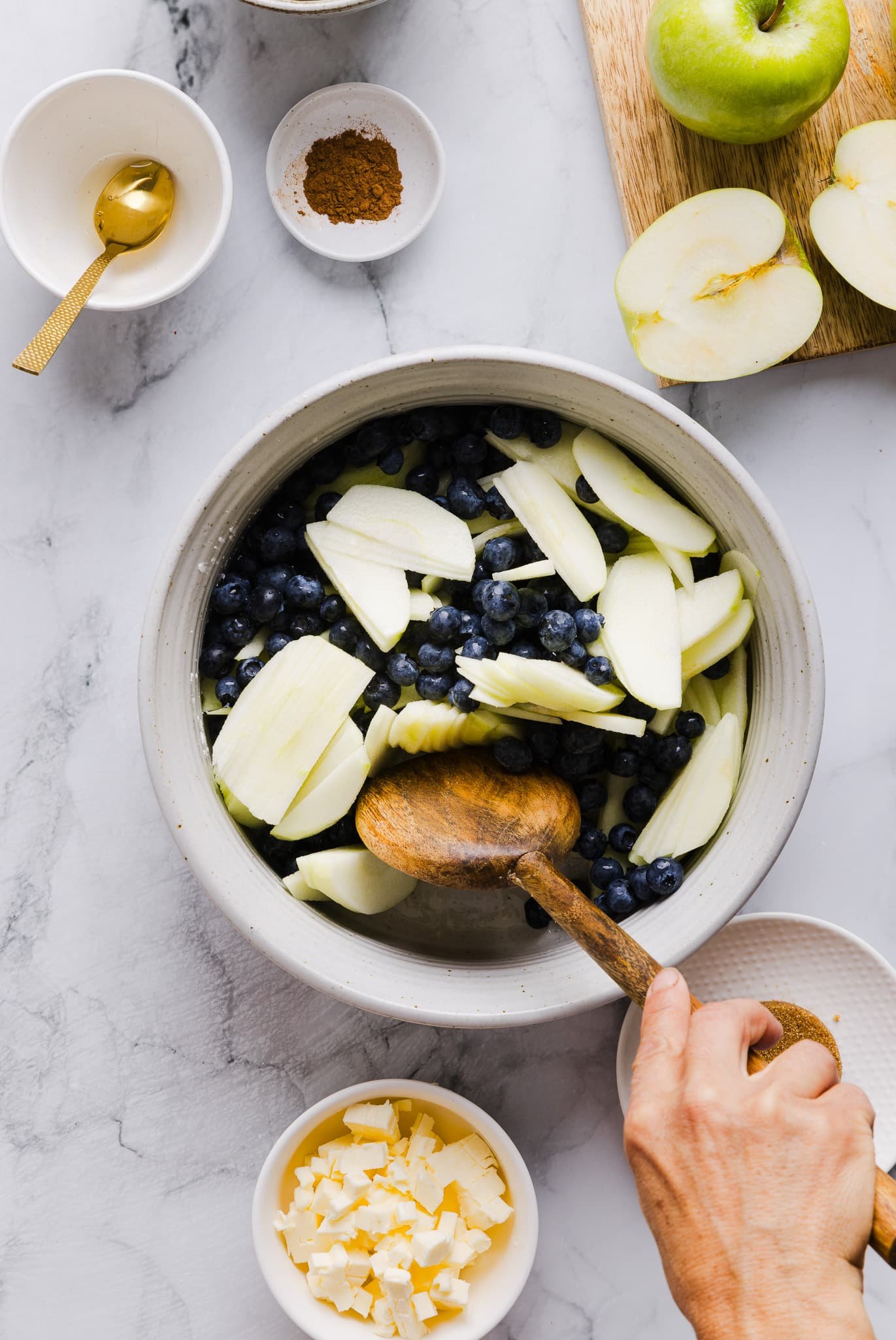 Tossing apples and blueberries with honey, lemon juice, and cornstarch.
