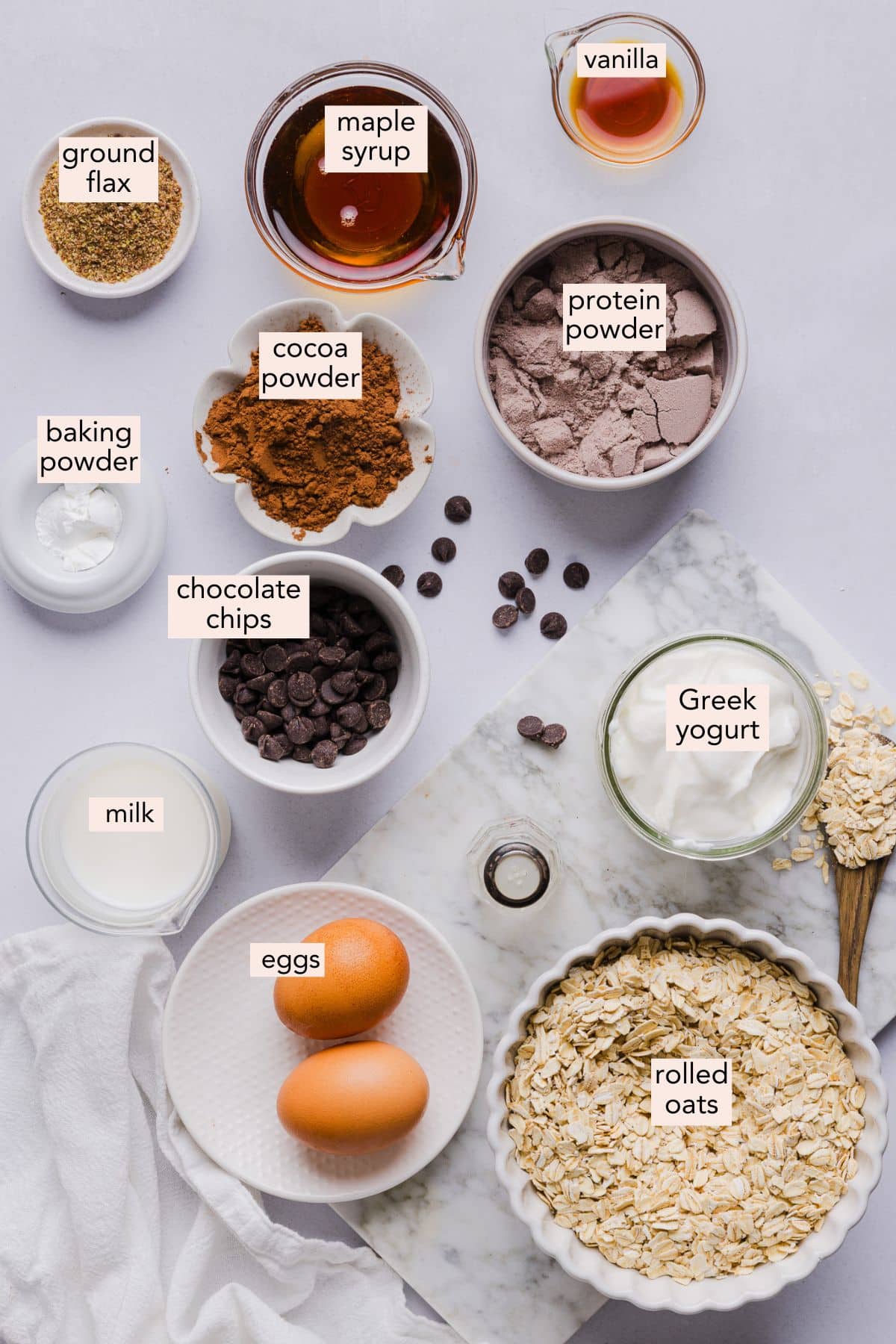 Ingredients for chocolate baked oats on a countertop with labels.