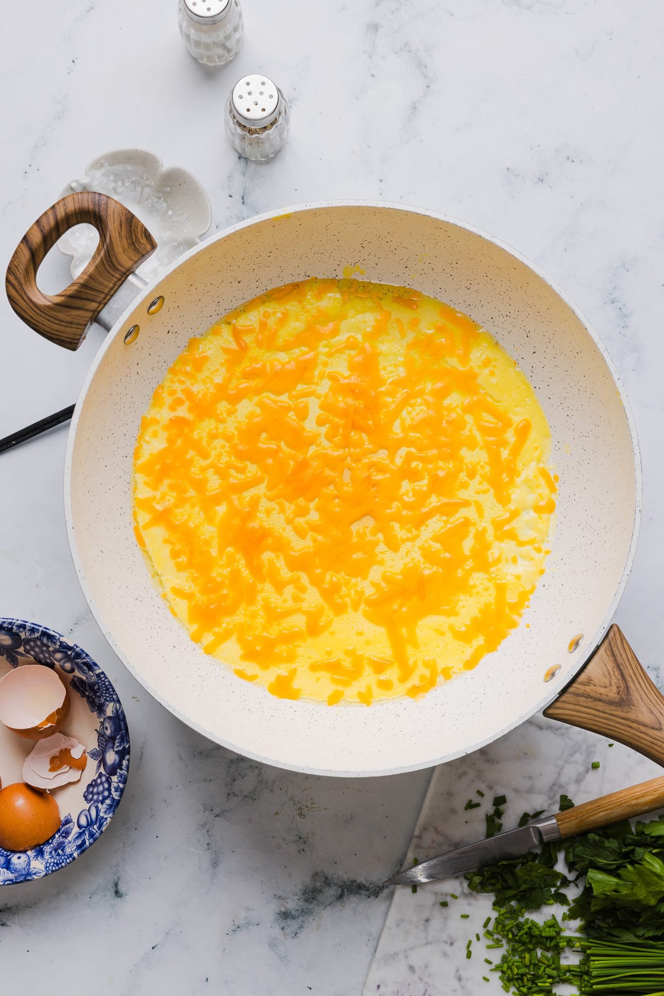 Adding cheddar cheese to a cottage cheese omelette.