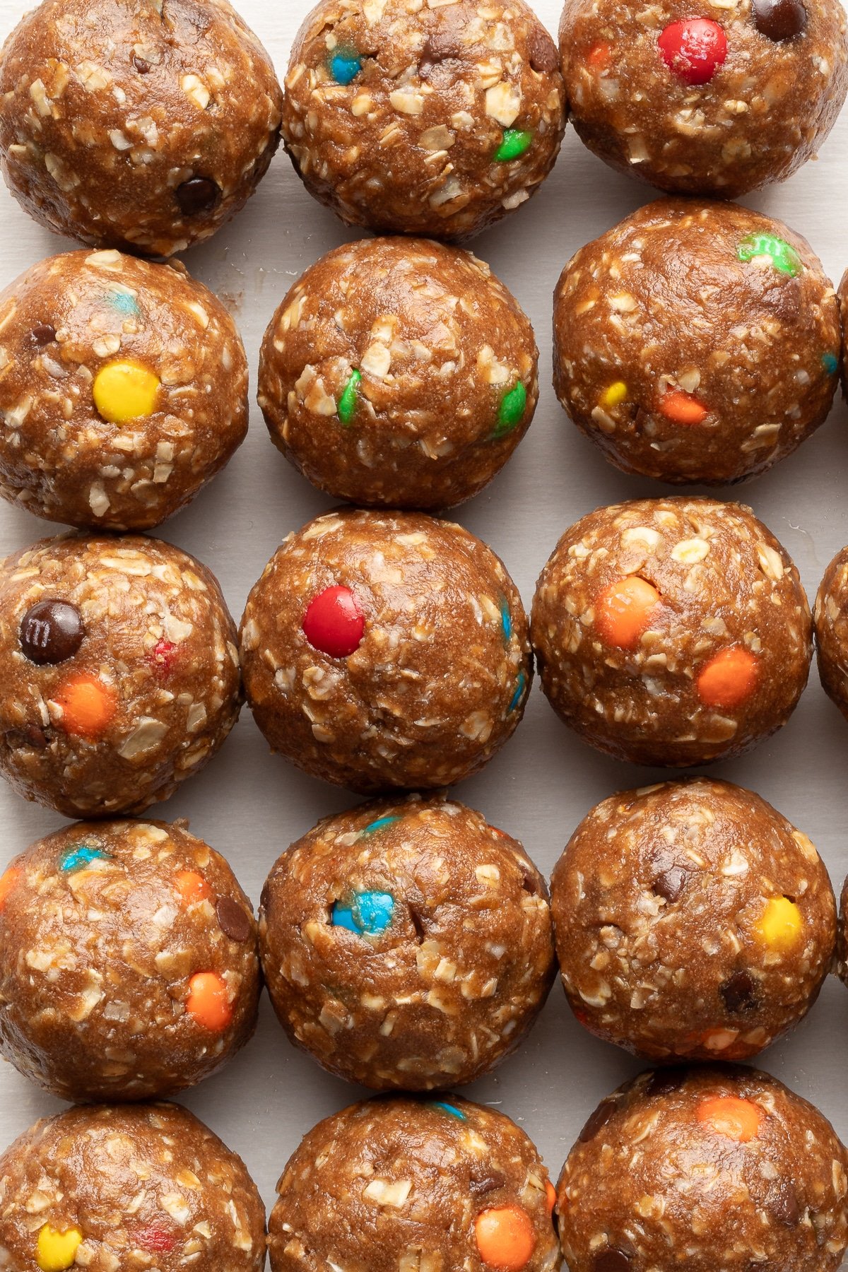 A close up shot of monster protein balls lined up on parchment paper.