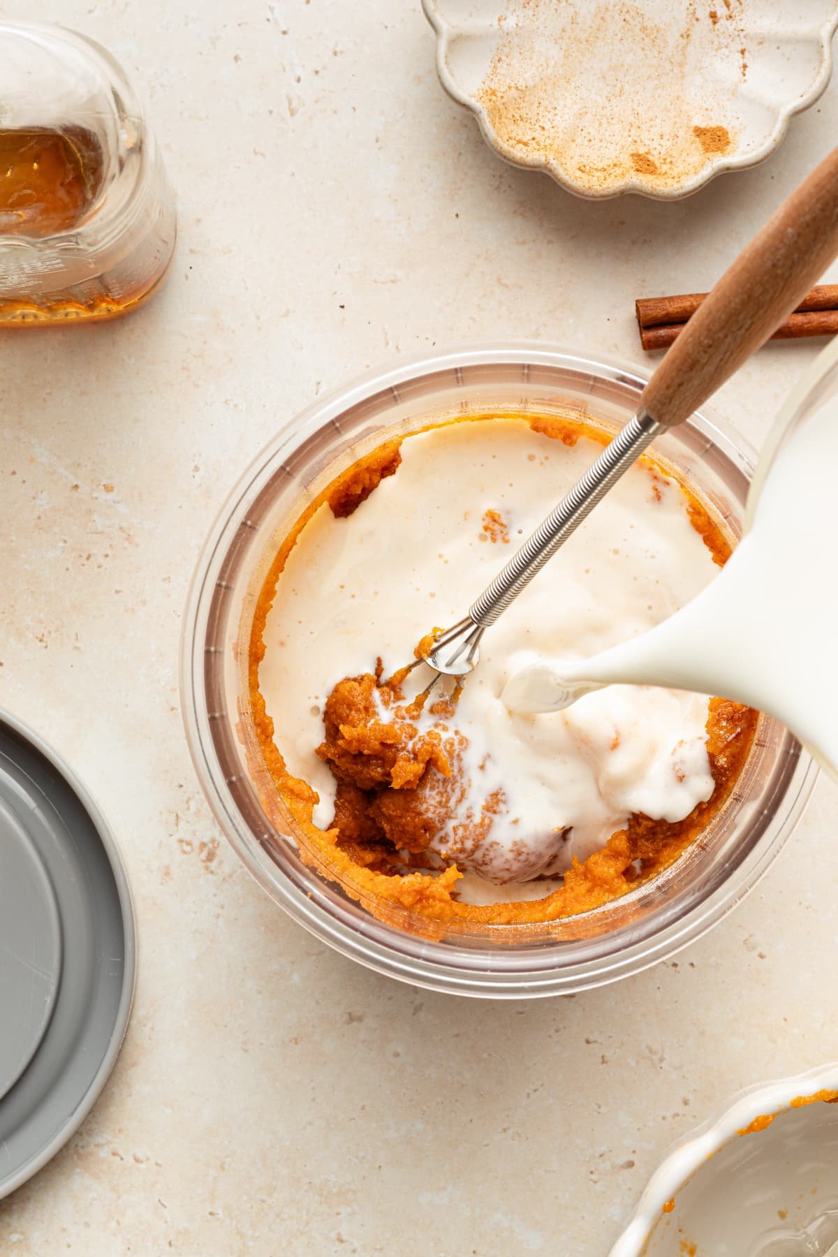 Ingredients for Ninja Creami pumpkin ice cream being poured into a pint container.