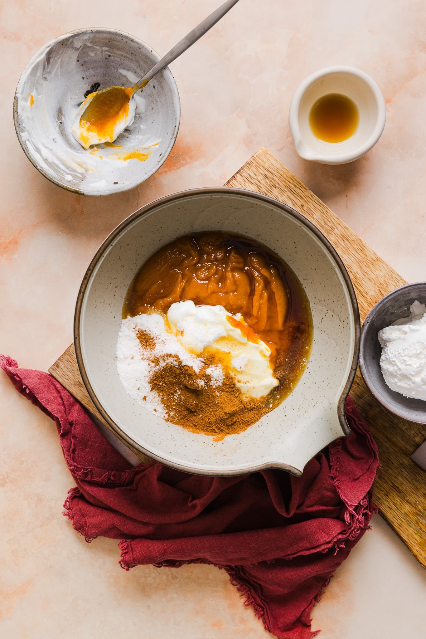 Pumpkin, yogurt, pudding mix, pumpkin pie spice, and maple syrup in a bowl.