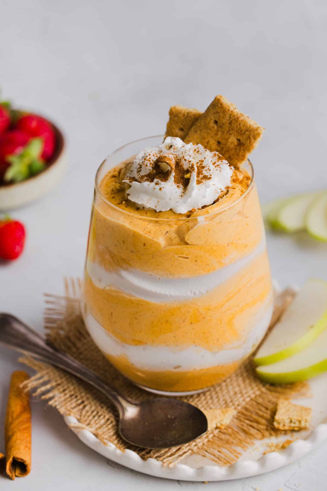 Pumpkin fluff layered with whipped cream in a glass.