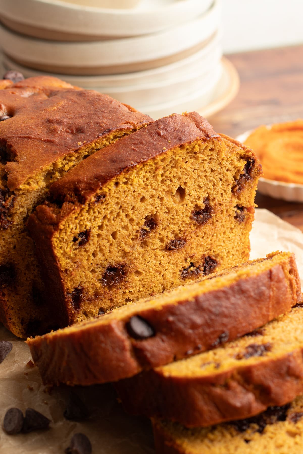 Pumpkin protein bread being sliced on a board.