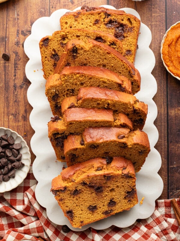 A loaf of pumpkin protein bread sliced on a platter.