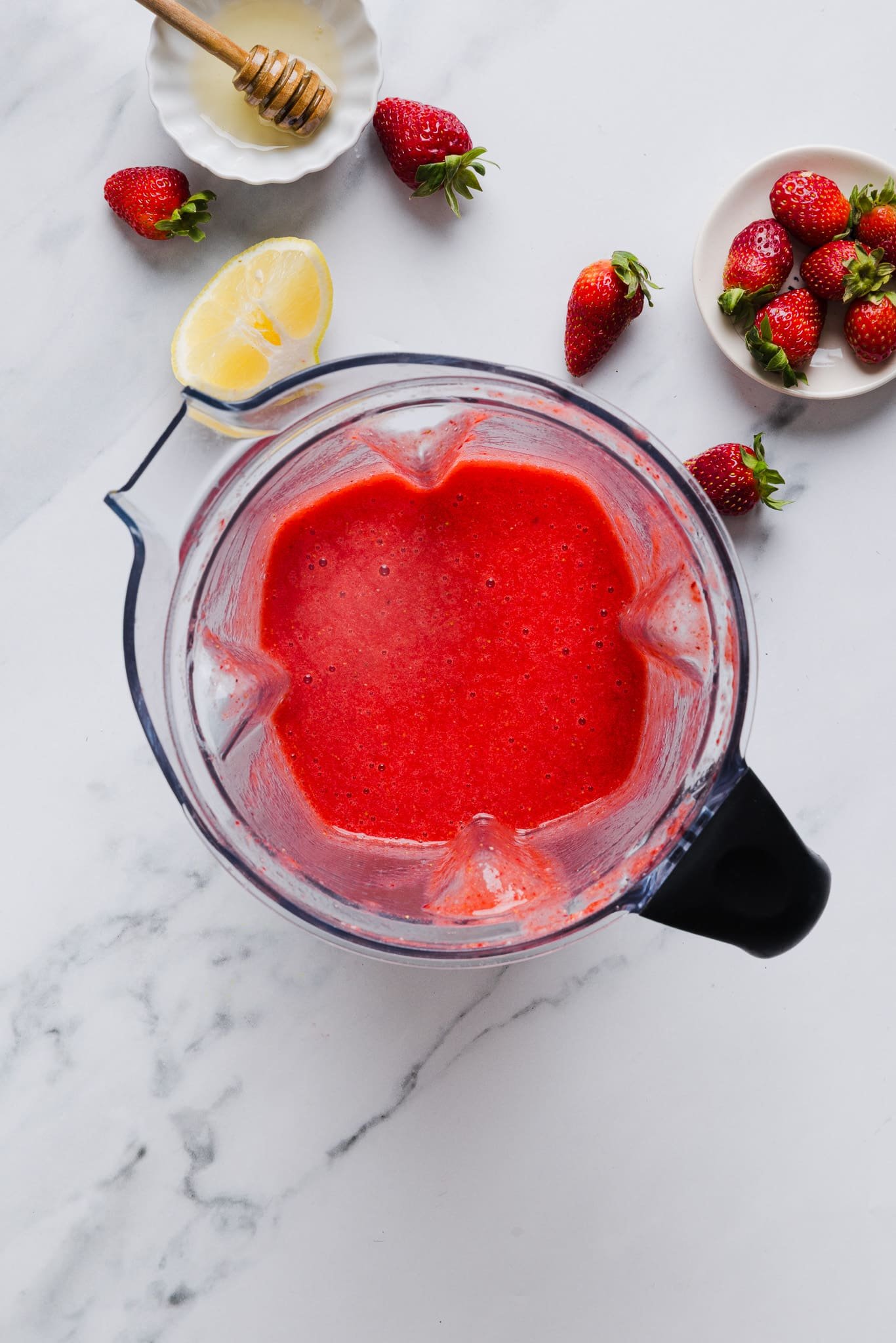 Strawberries blended in a blender for Ninja Creami strawberry sorbet.