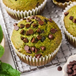 A spinach banana muffin on a cooling rack.