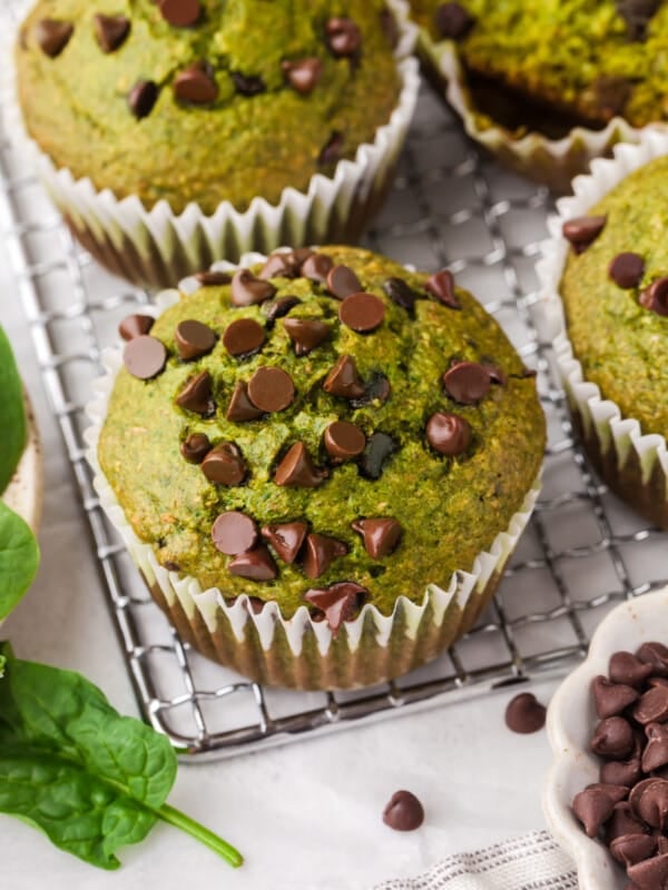 A spinach banana muffin on a cooling rack.