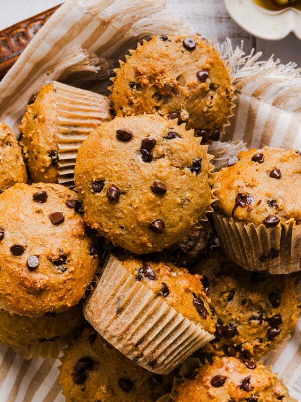 Cottage cheese banana muffins with mini chocolate chips in a pan with a stripped tea towel.